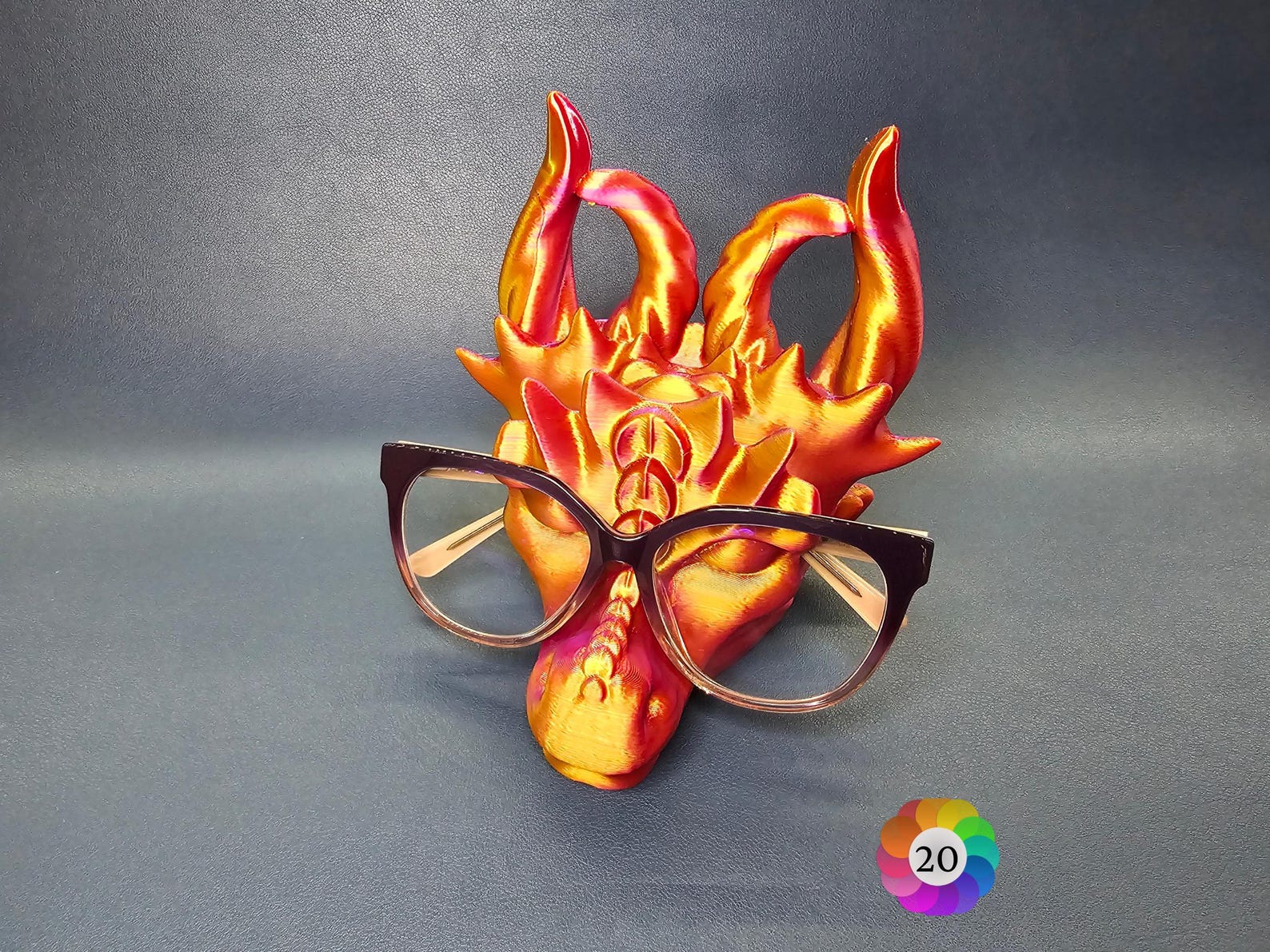 3D printed dragon glasses holder on a desk holding eyeglasses